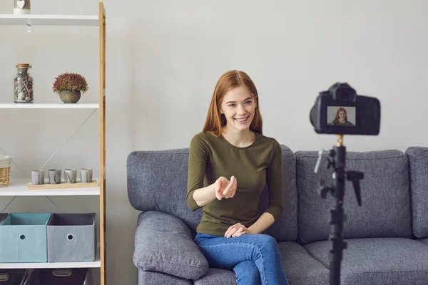 Blogger vlogger girl speaks to the camera while sitting on a sofa in a room at home. — Stock Photo, Image