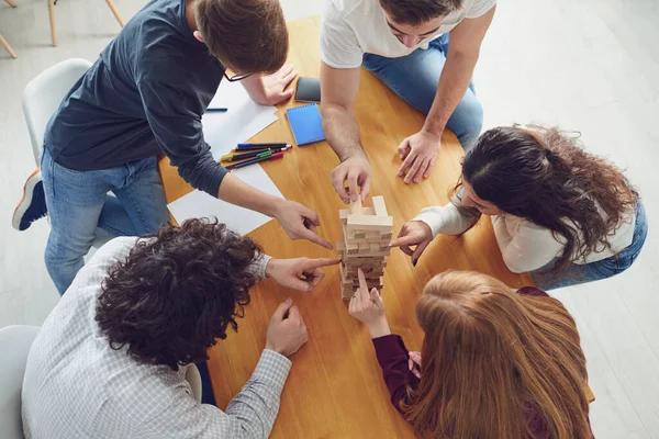 Jongeren hebben plezier met bordspelen aan een tafel in de kamer. — Stockfoto
