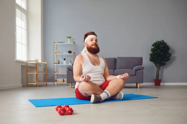 Dicker Mann meditiert in Lotusposition und sitzt zu Hause auf dem Boden — Stockfoto
