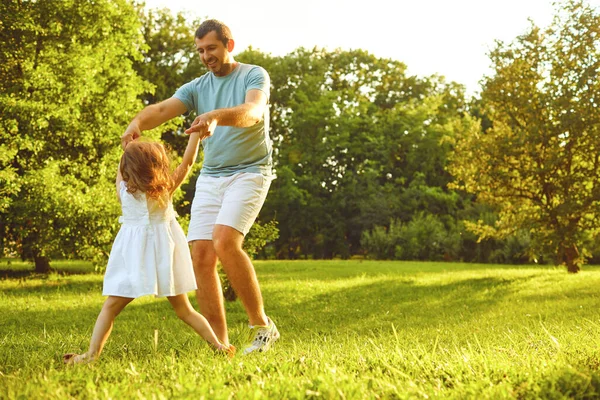 Fathers day. Father plays with his daughter in the summer park. — Stockfoto