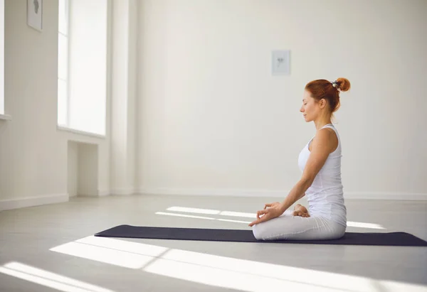 Chica del yoga. Chica de fitness está practicando yoga en una posición de loto sentado en un estudio — Foto de Stock