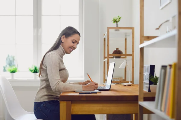 Learning study online. Young woman is studying a lesson video lecture while having a laptop workplace in the room. — Stock Photo, Image