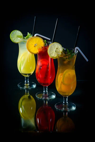 Cocktail fruttati refrigerati su sfondo nero specchiato con sli — Foto Stock
