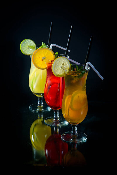 chilled fruity cocktails on a black mirrored background with sli