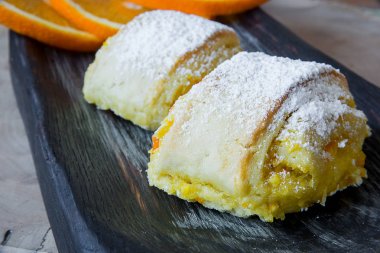 Turuncu bir dokulu kesme tahtası üzerinde rulo