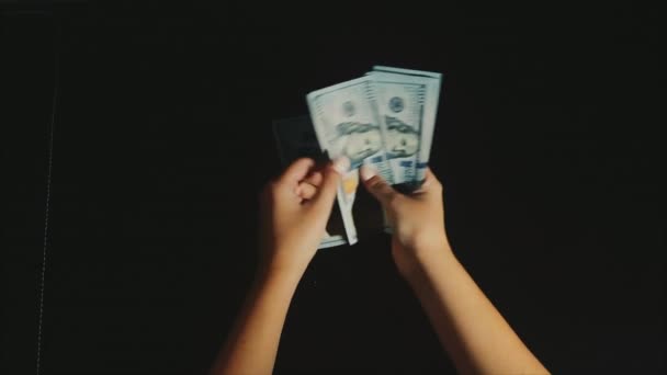 Las manos de la mujer cuentan y muestran un paquete de dólares en el fondo negro — Vídeo de stock