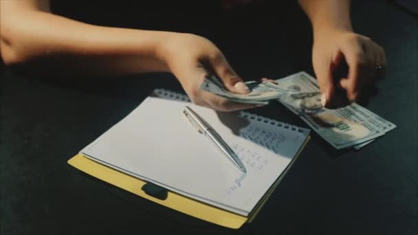 Концепція планування сімейного бюджету жінка має підрахувати долари і писати відходи — стокове відео