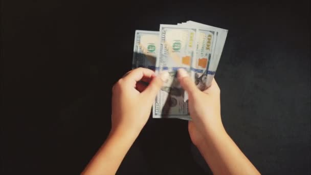 Le mani delle donne contano un pacchetto di dollari sullo sfondo nero — Video Stock