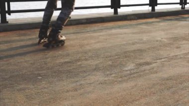 Bacaklar paten satır içi yakın çekim asfalt günbatımı üzerinde mans