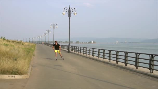 Giovane uomo sportivo pattinaggio a rotelle sul lungomare estivo — Video Stock