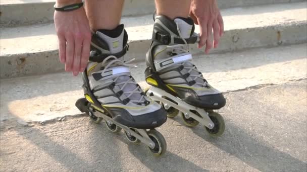 Homme se préparant pour le roller, portant des patins à roulettes — Video