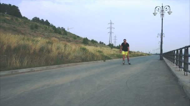 Νεαρός άνδρας σπορ με πατίνια βόλτα στην προκυμαία του καλοκαιριού — Αρχείο Βίντεο