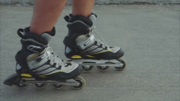 Patines de hombre patinaje en línea de cerca sobre el asfalto — Vídeo de stock