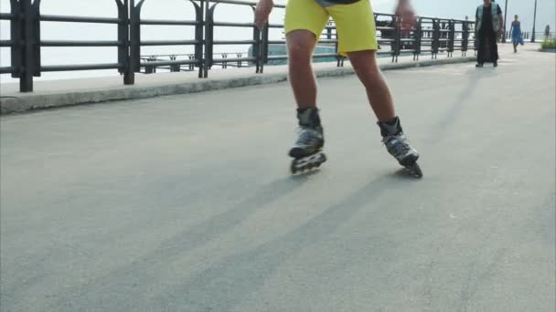 Mans benen rolschaatsen-inline close-up aan de waterkant — Stockvideo