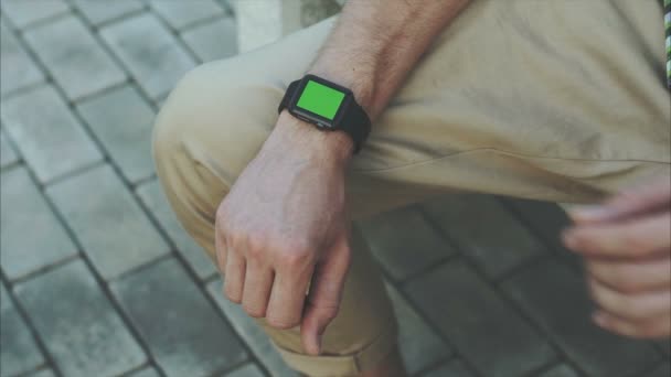 L'uomo passa gesti un moderno orologio intelligente con un contenuto chiave croma schermo verde — Video Stock