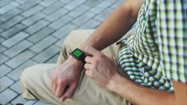 Les mains habillées décontractées utilisent une montre intelligente moderne avec un écran vert — Video