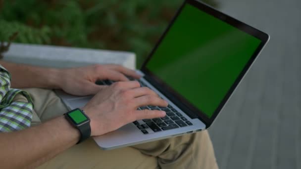 Hombre manecillas con reloj inteligente usando ordenador portátil pantalla verde — Vídeos de Stock