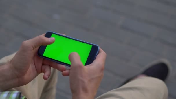 Mão de homem usando smartphone com tela verde — Vídeo de Stock