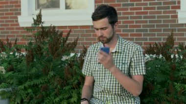 Genç adam sit tezgah ve onun arkadaşına cep telefonu kullanarak arama