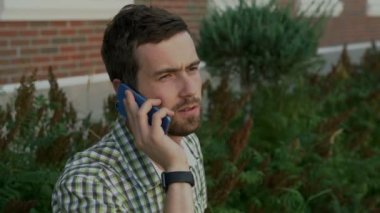 Bir cep telefonuyla konuşan genç adam