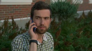 Genç giyen smartwatch bir cep telefonuyla konuşan adam