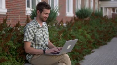 Laptop yanında sohbet tezgah videoda smartwatch sit giyiyor rahat giyimli adam