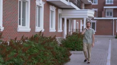 Sokakta yürüyen ve smartphone ağır çekim tarafından konuşurken rahat giyimli adam