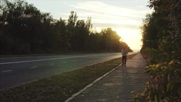 Senior homme aux cheveux gris jogging sur la rue de la ville coucher de soleil — Video