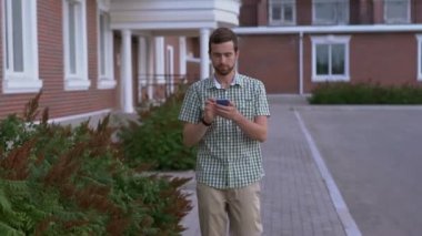 Smartwatch ile rahat giyimli adam sokakta yürümek ve onun smartphone kullanın