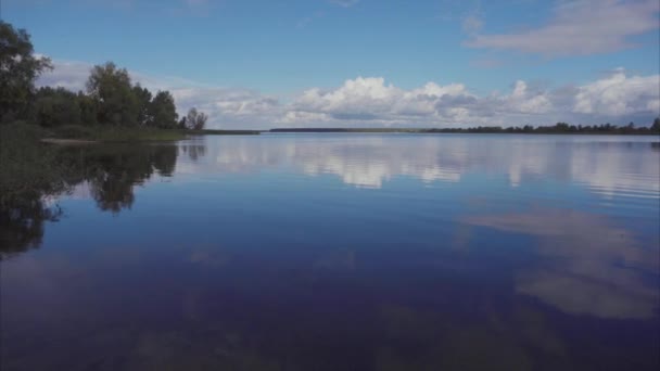 Una vista panorámica de un pequeño lago azul limpio con casas frente a él en Rusia — Vídeo de stock