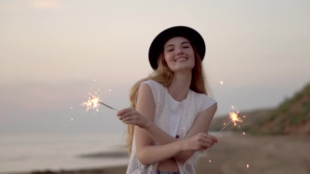 Adolescente bella ragazza con scintille sulla spiaggia al tramonto — Video Stock