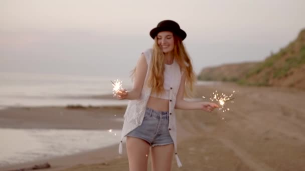 Csillagszórók a tengerparton napnyugtakor tizenéves gyönyörű lány — Stock videók