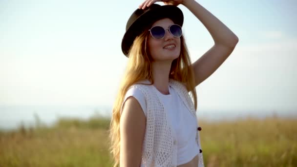 Jonge mooie vrouw model in hoed en zonnebril poseren buiten Slowmotion — Stockvideo