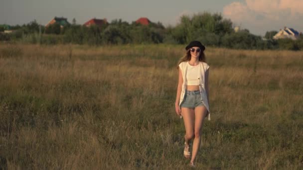 Jonge mooie vrouw model op de weide lopen en genieten van de natuur — Stockvideo