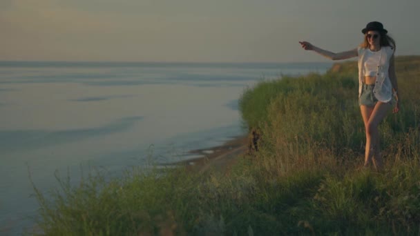 Jeune femme en promenade danser et sauter sur le bord d'une falaise profiter de la nature — Video