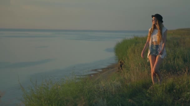 Jovem mulher em passeio na beira de um penhasco apreciando a natureza — Vídeo de Stock