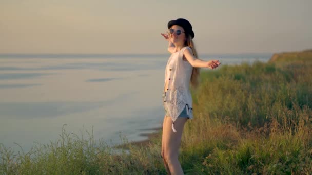 Mujer joven bailando a pie y saltando al borde de un acantilado disfrutando de la naturaleza — Vídeos de Stock