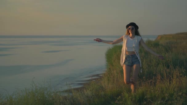 Mujer joven bailando a pie y saltando al borde de un acantilado disfrutando de la naturaleza — Vídeos de Stock