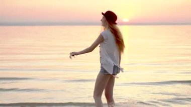 Mutlu yaz tatili okyanus golden sunset bulvarında zevk şapkalı sarışın genç kadın