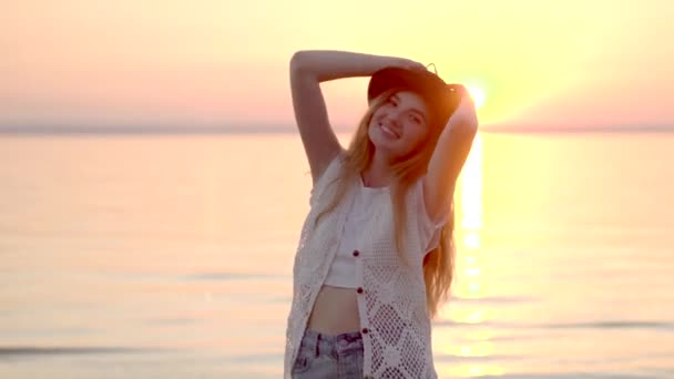 Pretty blonde woman in hat enjoying summer vacation on the ocean golden sunset — Stock Video