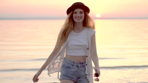 Όμορφη ξανθιά γυναίκα με καπέλο απολαμβάνοντας καλοκαιρινές διακοπές με ηλιοβασίλεμα ωκεανό Χρυσή — Αρχείο Βίντεο