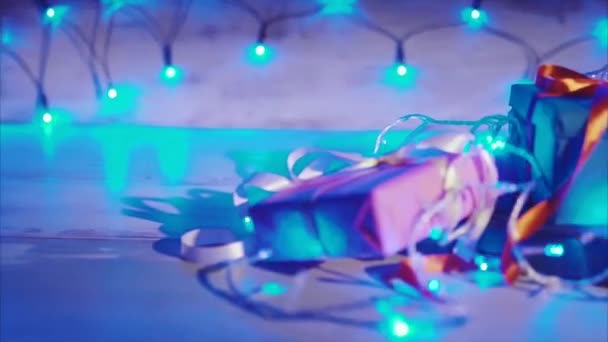 Nahaufnahme von Weihnachts- und Neujahrsgeschenken mit blauem Blinkkranz — Stockvideo