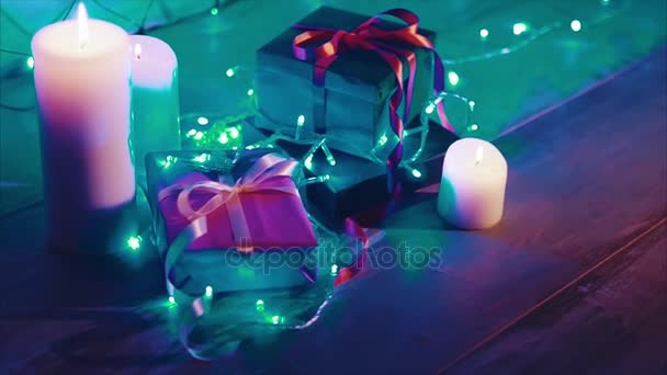 Close-up van Kerstmis en Nieuwjaar geschenkdozen en kaarsen met blauwe garland — Stockvideo