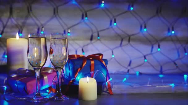 Jul och nyår presentaskar, stearinljus och två glas champagne — Stockvideo
