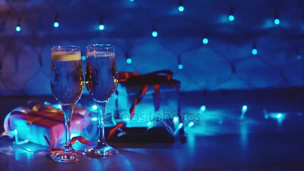 Kerst en nieuw jaar geschenkdozen en twee glazen van borrelende champagne — Stockvideo