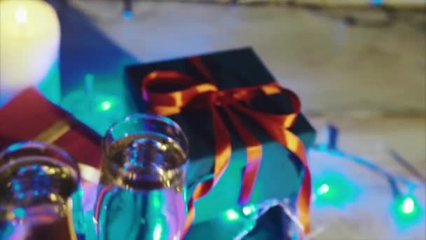 Vánoce a nový rok dárky, svíčky a dvě sklenice šampaňského — Stock video