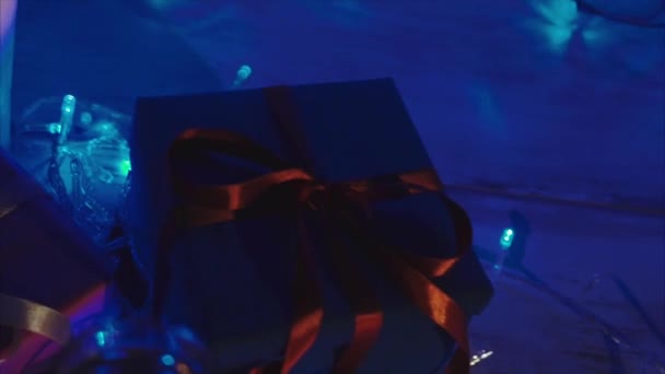 Weihnachts- und Neujahrsgeschenke, Kerzen und zwei Gläser Champagner — Stockvideo
