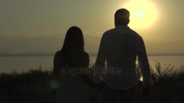 Mutlu genç bir çift deniz için aşk ve ilişkiler günbatımı kavramı üzerinde git.