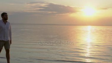 Denize yakın günbatımı üzerinde yürüyen genç mutlu çift. Aşk kavramı.