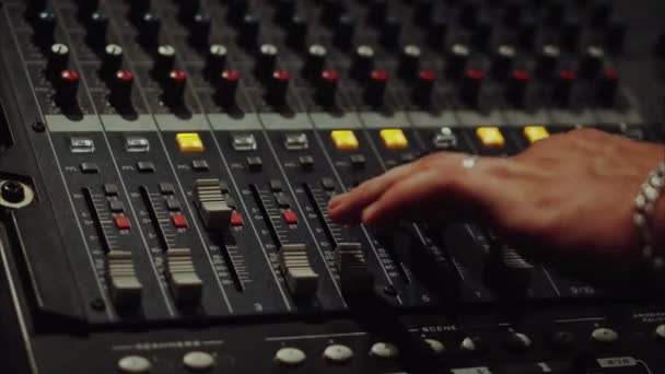 Recording studios audio console and a hand pulling up the knobs — Stock Video